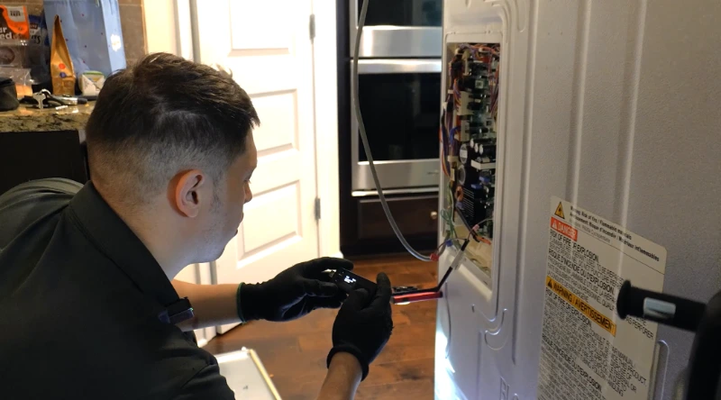 Local appliance repair technician diagnosing a refrigerator cooling issue
